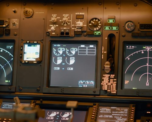 Airplane cockpit with flying command on control panel and dashboard for navigation, engine throttle and radar compass. Plane cabin with windscreen, buttons and handle. Close up.